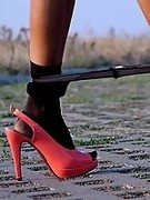 Teasing by sexy legs in black pantyhose and high heels outdoor